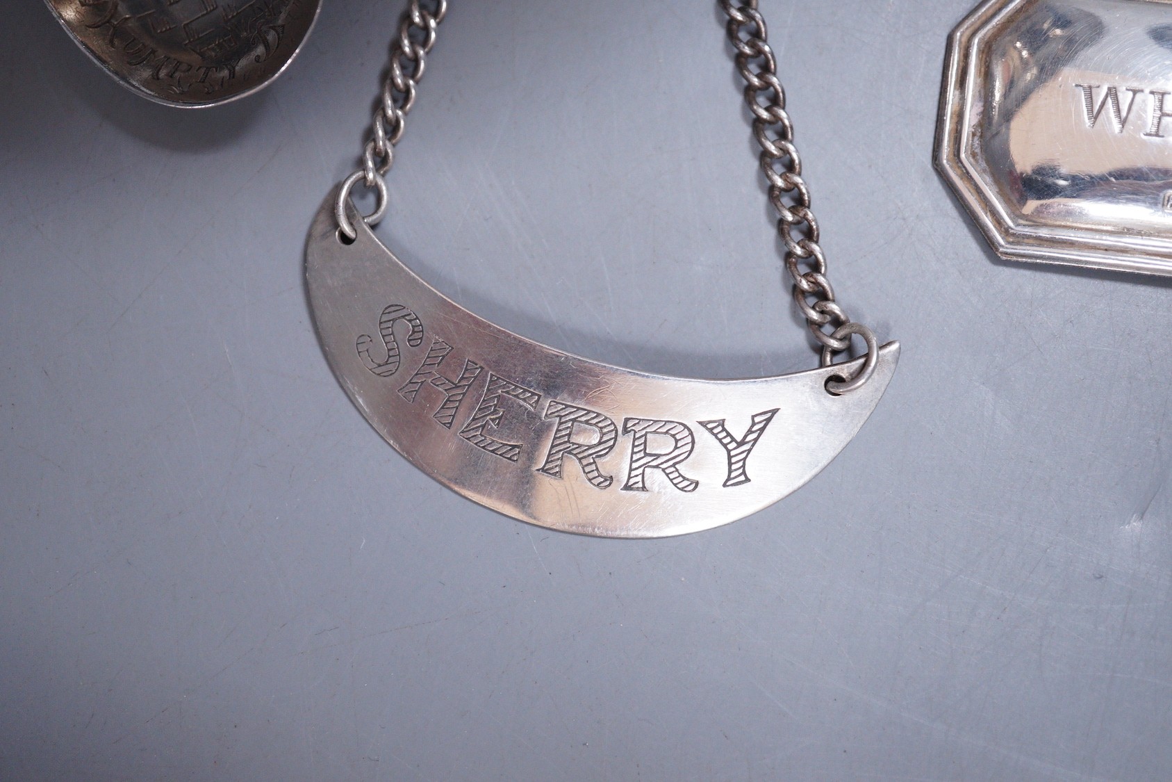 A group of small silver and white metal items including a sterling pedestal bowl. sterling 'Humpty Dumpty' child's spoon, a silver wine label, a sterling wine label, pierced silver lid and a sterling small vase